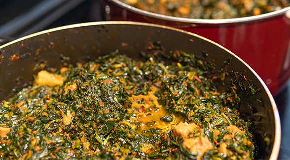 efo riro being cooked in red pots 