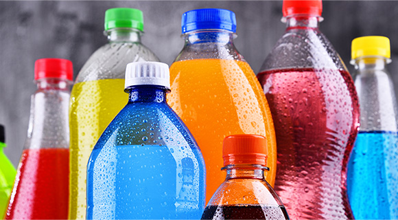 an image of assorted drinks of different colours in plastic bottles